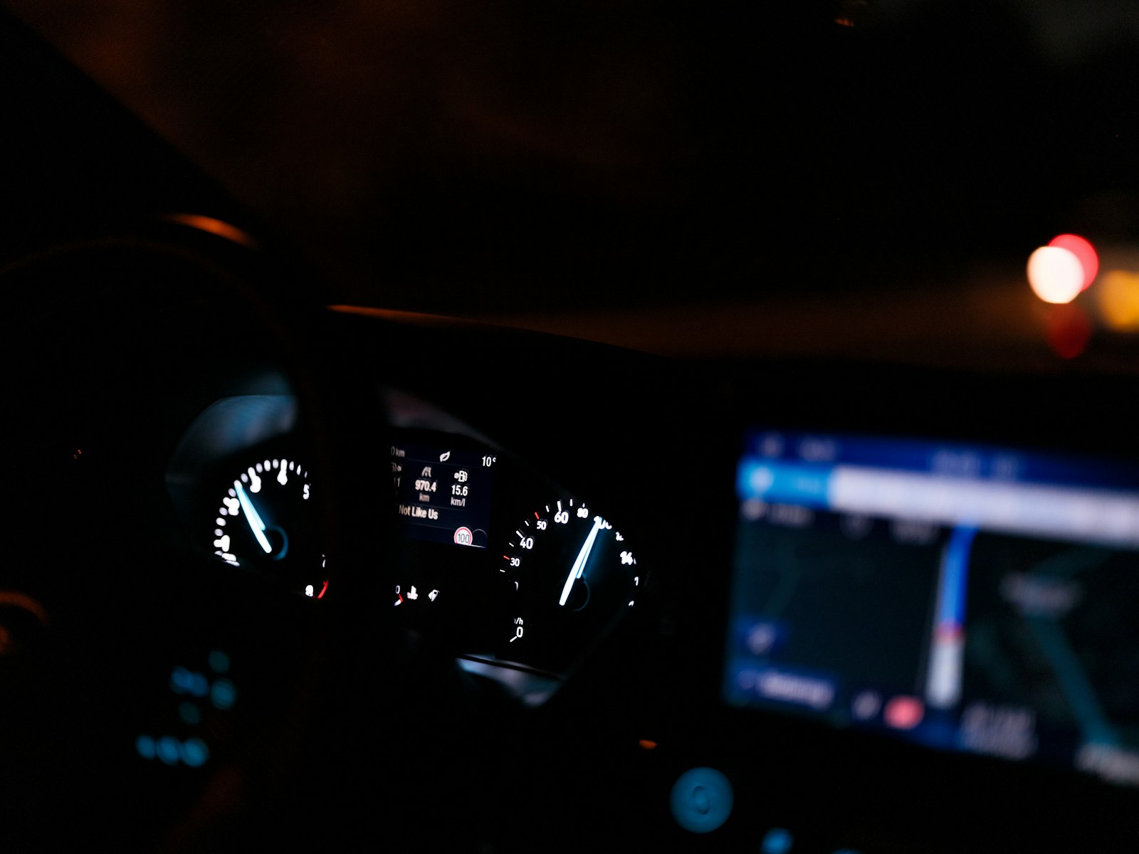 Beleuchtetes Armaturenbrett eines Autos bei Nacht