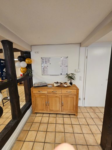 Eingangsbereich der Fahrschule mit dunklen Fachwerkbalken, Sideboard und Infotafel