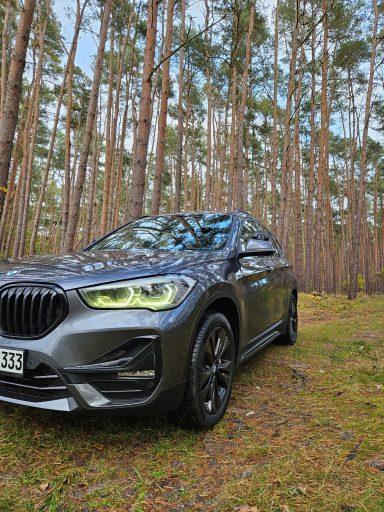 Der graue BMW X1 der Fahrschule Wahl im Kiefernwald
