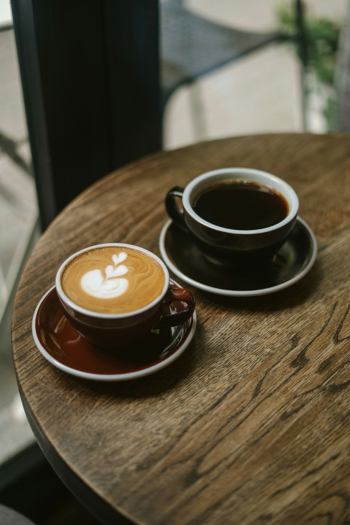 Zwei Tassen Kaffee auf einem runden Holztisch