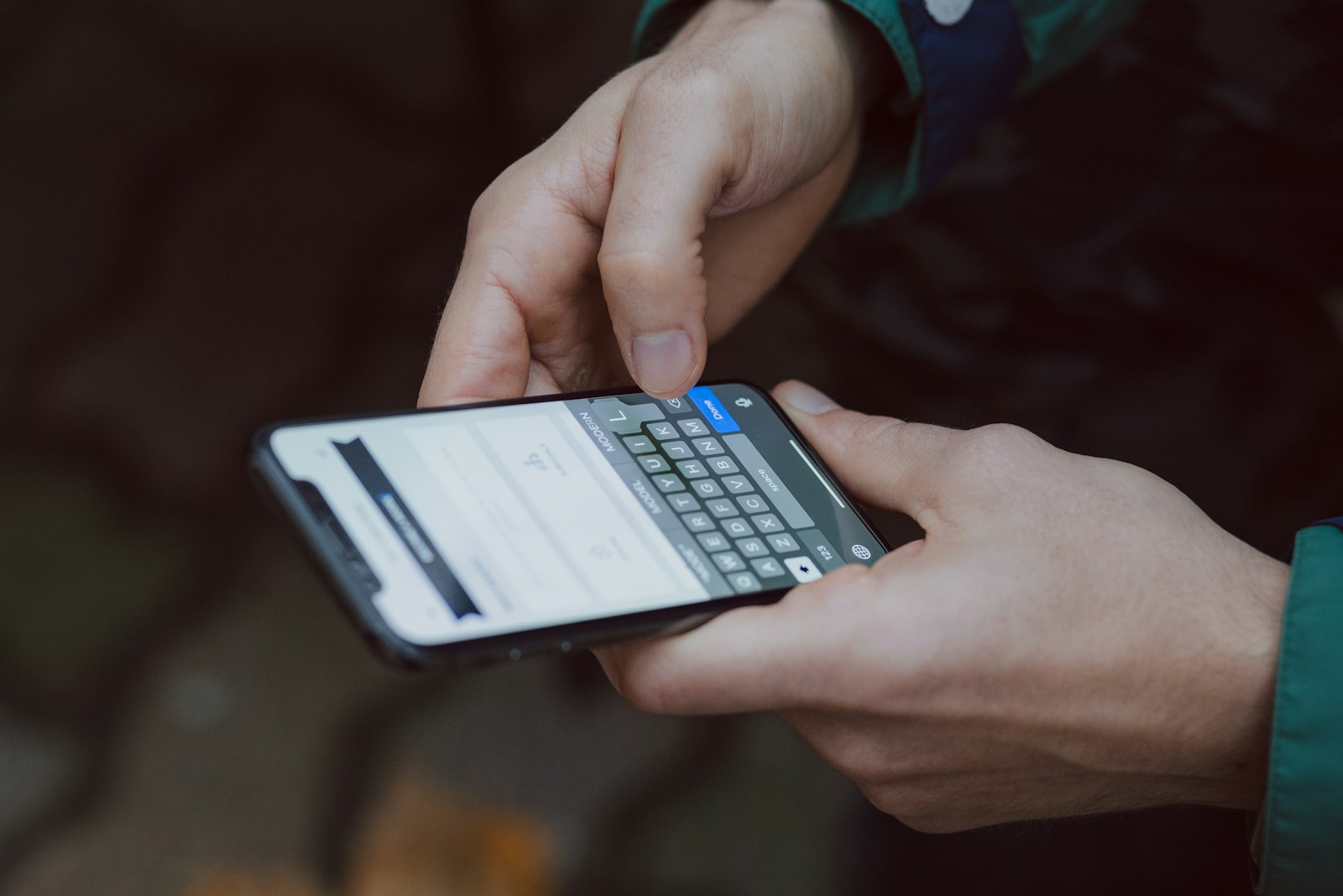 Zwei Hände tippen eine Nachricht in ein Smartphone